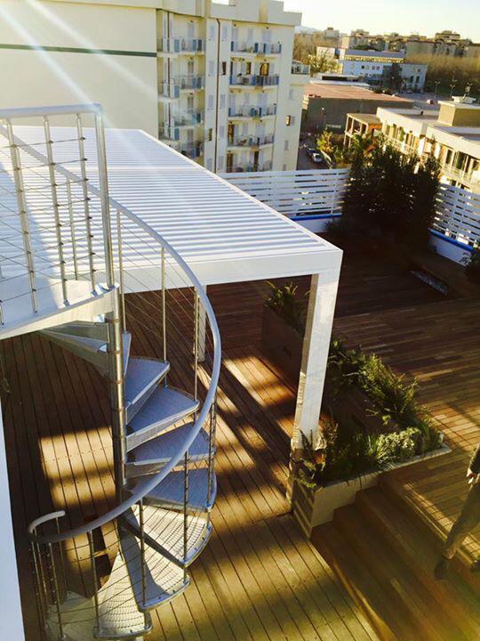una scala a chiocciola sul tetto di un edificio con Coperture solari.